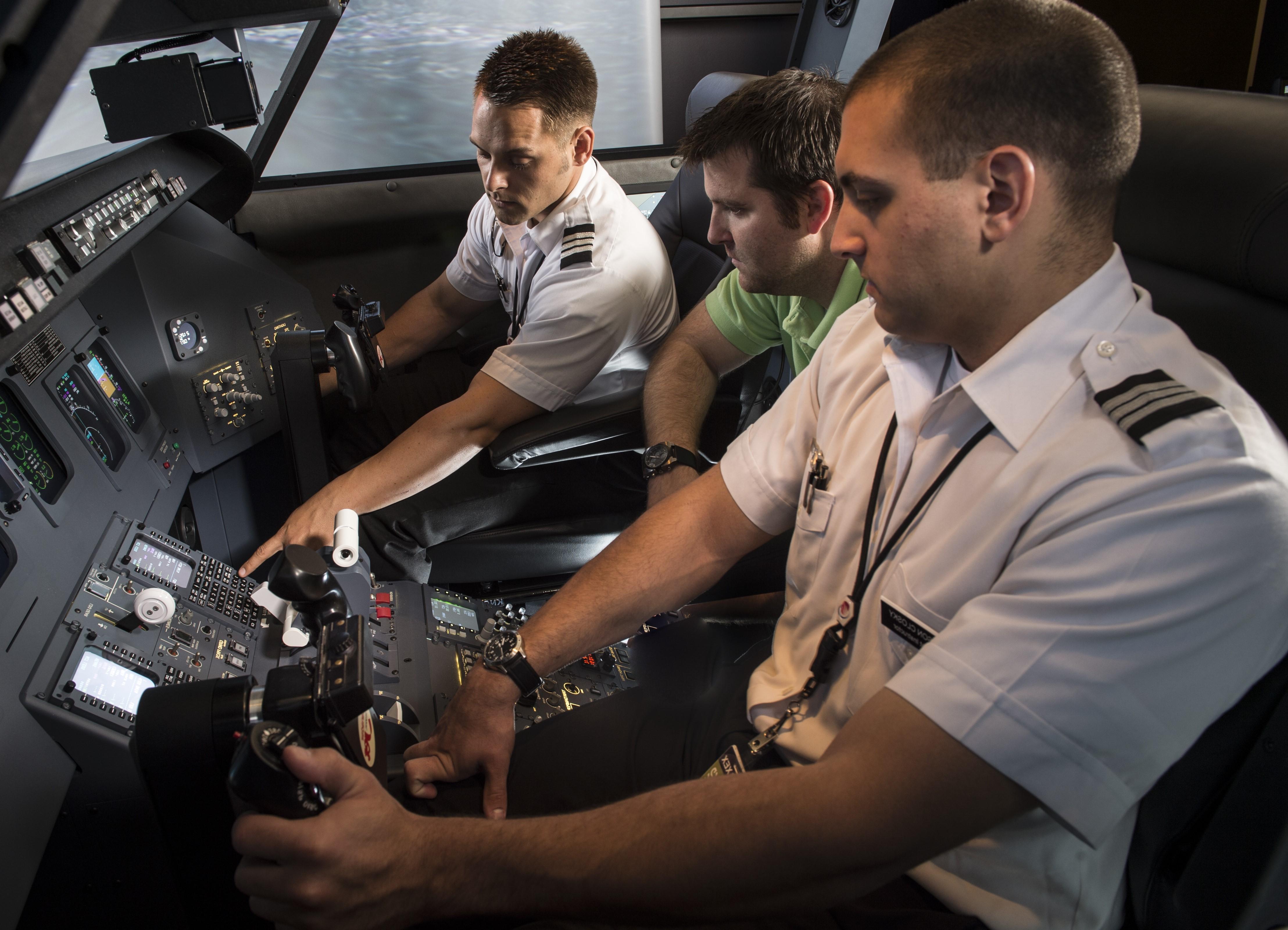 Two students in flight simulator.